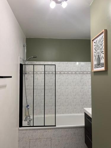 a bathroom with a shower and a bathtub with a glass door at Résidence Les Oliviers, La Défense 20 mn, 4 to 6 people in Bezons