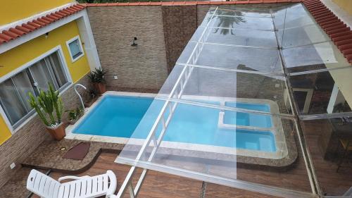 a swimming pool in front of a house at Casa 05 - Grande Família in Angra dos Reis
