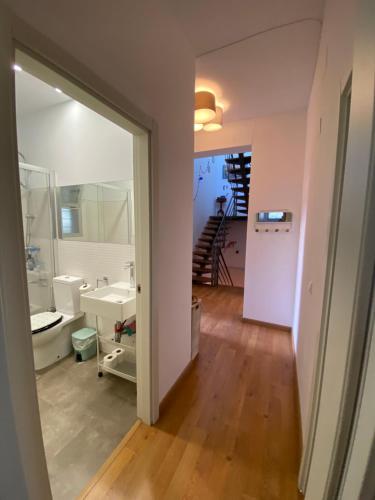 a room with a bathroom with a sink and a staircase at Skydiversnestdotcom in Bollullos de la Mitación