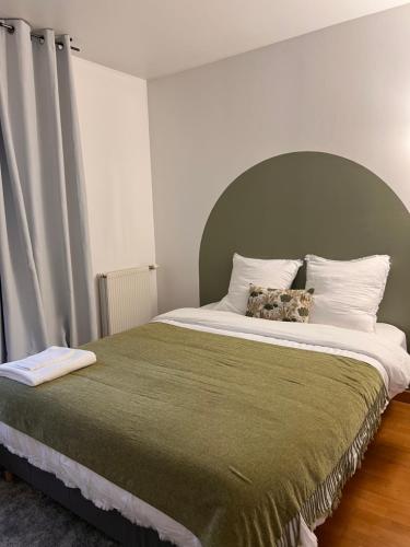 a bed with a stuffed animal sitting on top of it at Résidence Les Oliviers, La Défense 20 mn, 4 to 6 people in Bezons