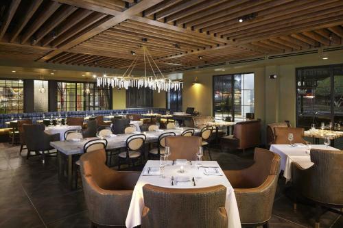 a restaurant with tables and chairs and a chandelier at The Burgess Hotel, Atlanta, a Tribute Portfolio Hotel in Atlanta