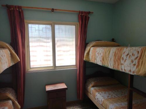 a room with two bunk beds and a window at Cabañas Los Pinos in Potrero de los Funes