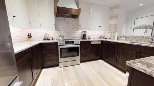 a kitchen with wooden cabinets and white appliances at Christiania Condominiums- CoralTree Residence Collection in Vail