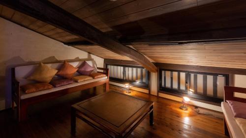 a living room with a couch with pillows on it at Machiya Club Honkan in Omihachiman