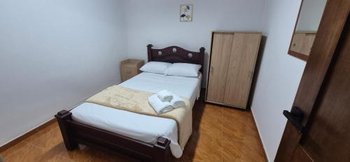 a small bedroom with a bed with two towels on it at Casa Campestre Villa Isabel tu Escape Perfecto in Cali
