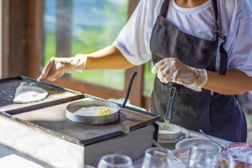 een persoon die eten kookt op een grill in een keuken bij Amoaras Resort in Maria Farinha