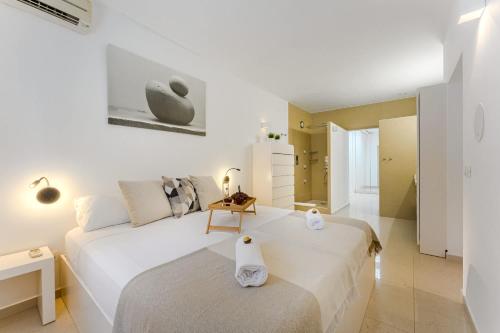 ein weißes Schlafzimmer mit einem großen Bett in einem Zimmer in der Unterkunft Palmera Sky Terrace Suite in Las Galletas