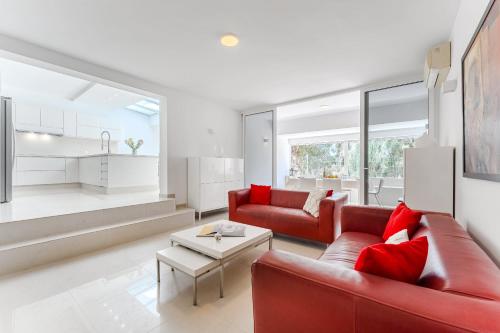 ein Wohnzimmer mit einem roten Sofa und einem Tisch in der Unterkunft Palmera Sky Terrace Suite in Las Galletas