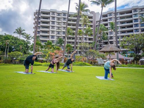 a group of people doing yoga in a park at Kaanapali Alii 2 Bedroom Ocean View in Kaanapali