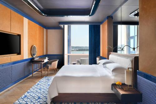 a hotel room with a large bed and a television at The Ritz-Carlton, Doha in Doha