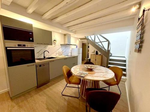 Escapade grenadoise في Larrivière: مطبخ مع طاولة وكراسي في الغرفة