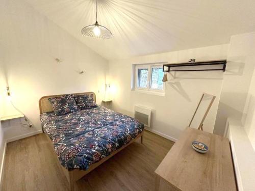 Escapade grenadoise في Larrivière: غرفة نوم صغيرة مع سرير وطاولة