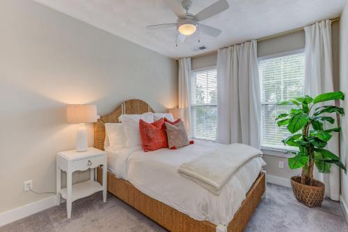 a bedroom with a bed and a plant and windows at 517 The Southend Pier House in Virginia Beach