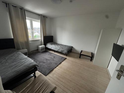 Ransbach-BaumbachにあるGanze Wohnung mit großem Parkplatz-Nähe A3のベッドと窓のある小さな部屋