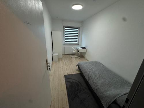 Ransbach-BaumbachにあるGanze Wohnung mit großem Parkplatz-Nähe A3のベッドと机と窓のある寝室