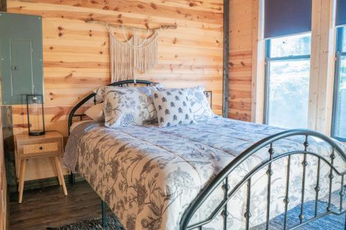 a bed in a room with a wooden wall at Bourbon Barrel Cottages #5 on Ky Bourbon Trail in Lawrenceburg