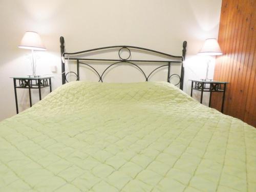 een slaapkamer met een bed en 2 bijzettafels bij Le gite de nogaro in Pontonx-sur-lʼAdour