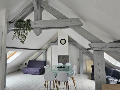 ein Esszimmer mit einem Tisch und Stühlen im Dachgeschoss in der Unterkunft Charming 3-room apartment in Thionville