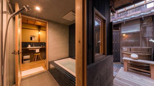 a bathroom with a bath tub and a shower stall at まちや倶楽部別館 in Omihachiman