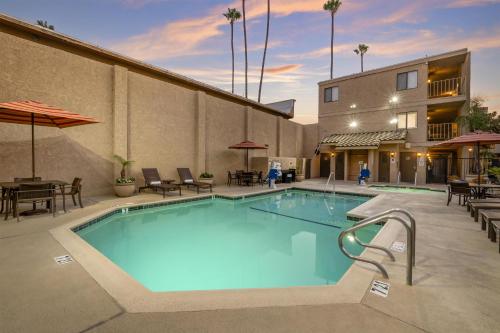 a pool at a hotel with tables and chairs at Best Western Plus Anaheim Inn in Anaheim
