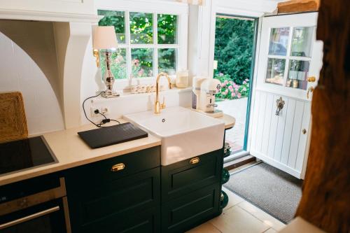 伦布鲁Cottage mit Kamin und Garten, seenah的带水槽和窗户的厨房