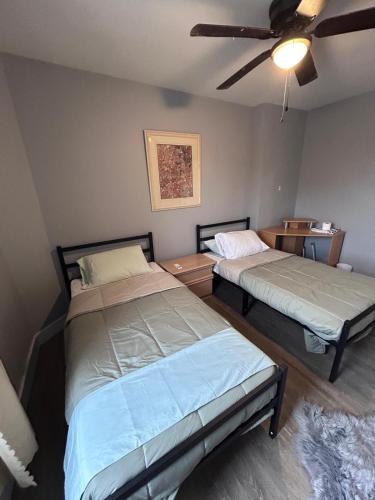 a bedroom with two beds and a ceiling fan at Baby Hotel By BYD in Windsor