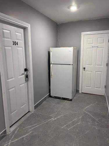 a kitchen with a white refrigerator and two doors at Baby Hotel By BYD in Windsor
