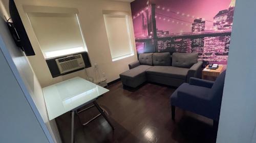 a small living room with a couch and a chair at Night Hotel Broadway in New York