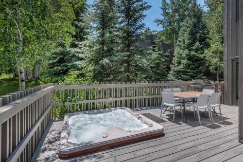 a hot tub on a deck with a table and chairs at Meadow Ranch 384 Private Outdoor Hot Tub in Snowmass Village