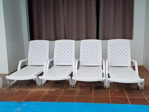 three white chairs sitting next to each other at Le Mirage GT in Taxisco