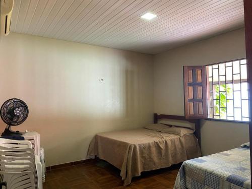 ein Schlafzimmer mit einem Bett und einem Fenster in der Unterkunft Casa Confortavel em balneario Alter do Chão Santarem Pará in Santarém