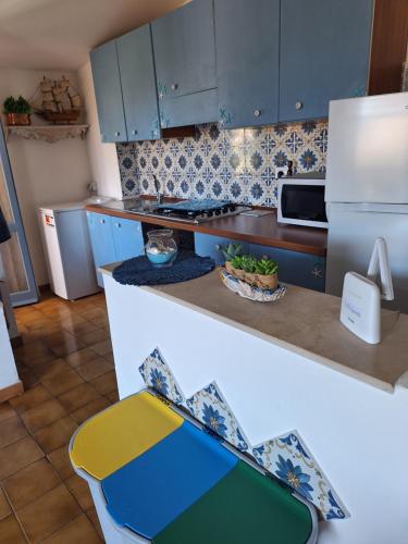 Una cocina con gabinetes azules y un refrigerador blanco. en Appartamento Oasi Azzurra, en Sellia Marina