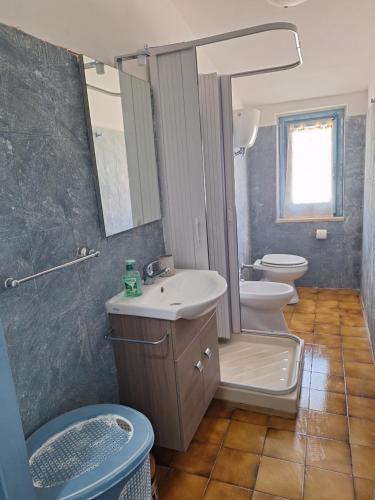 Un baño con lavabo, inodoro y espejo. en Appartamento Oasi Azzurra, en Sellia Marina