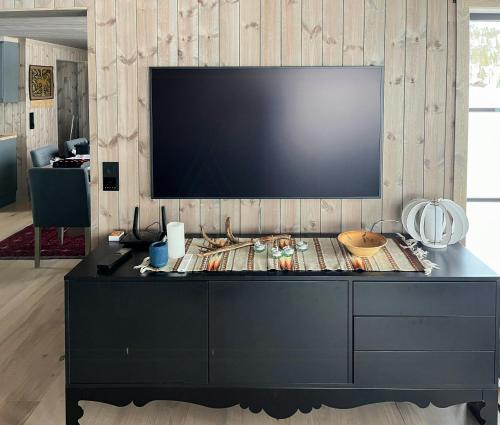 un grande centro di intrattenimento nero con una TV a schermo piatto su una parete di Nature-Close Cabin By The Water a Eggedal