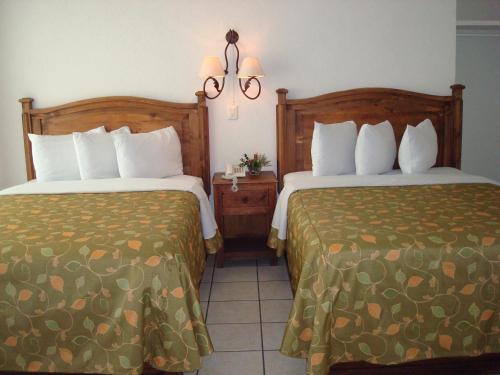 una camera d'albergo con due letti l'uno accanto all'altro di Hotel La Vista a San Martín Texmelucan de Labastida