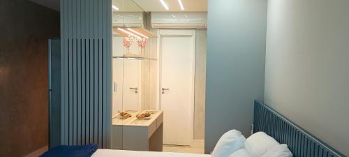 a bedroom with a bed and a sink and a mirror at Studio Luxuoso vista Mar in Salvador