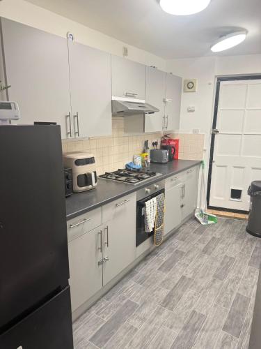 a kitchen with white cabinets and a black refrigerator at Saunders house in Gillingham