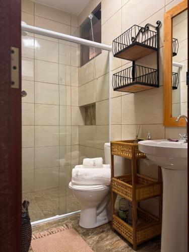 a bathroom with a toilet and a sink and a shower at Trindade - Suíte Mandala in Trindade