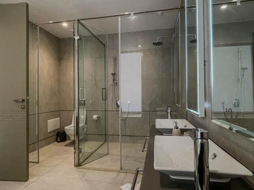 a bathroom with two sinks and a glass shower at M Résidence Marrakech Luxury Serviced Apartments in Marrakesh