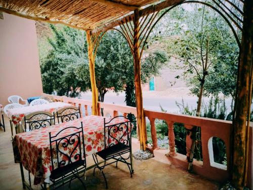 a room with a table and chairs on a balcony at Riad hotel Étoile dades Camping in Aït Ali Ou Allah