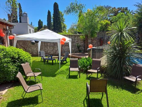 a group of chairs and a white umbrella in a yard at Quinta El Zorzal in La Unión