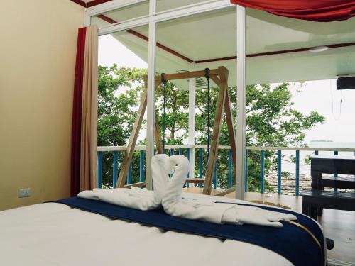 a bed with white pillows in front of a window at Jlb resort and tours,Guest House in Valdez