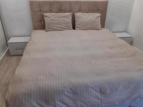 a bed in a bedroom with two tables and a bedspread at Promenada Mall Apartment4you in Craiova