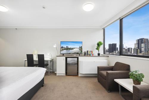a bedroom with a bed and a desk and chairs at Central Brisbane Studio with Stunning River Views in Brisbane