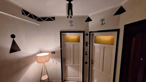 a hallway with two white doors and black triangles on the wall at Horus key Nile View in Aswan