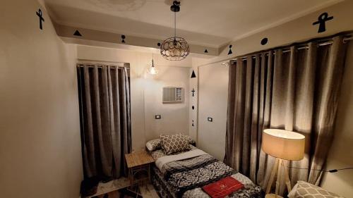 a room with a bed and a lamp and curtains at Horus key Nile View in Aswan