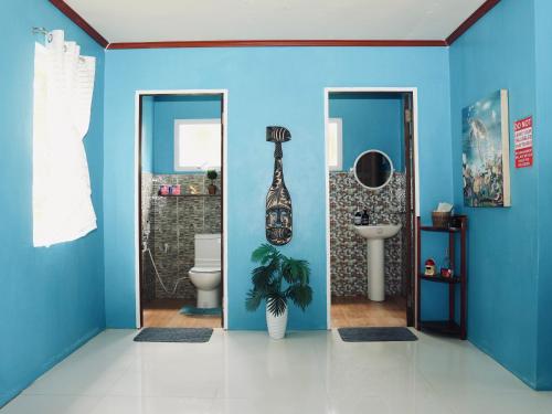 a blue bathroom with a toilet and a sink at Jlb resort and tours,Guest House in Valdez