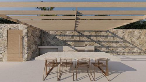 mesa con 4 sillas y pared de piedra en Vog Villa, en Tirane