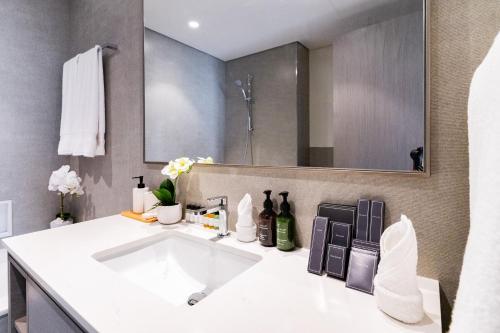 Un baño con un lavabo blanco y un espejo. en Luxury Grande 48 with Burj Khalifa & Fountain Views, en Dubái