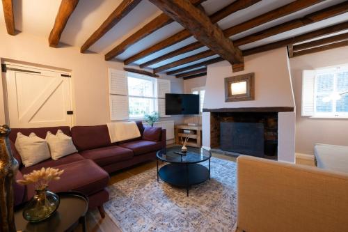 a living room with a couch and a fireplace at Charming 3BR Cottage Sleeps 8 - 15 Mins to Centre in Wickhambreaux